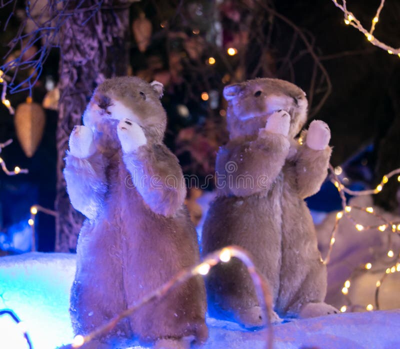 Two toy gophers on the background of an artificial forest and snow. Christmas and New Year concept.