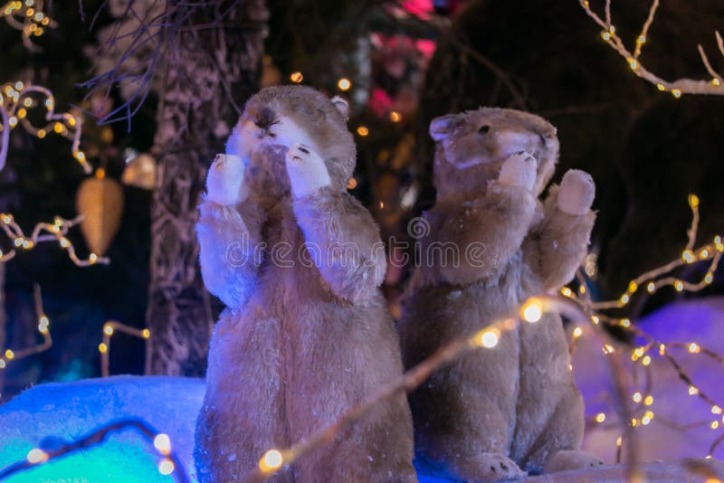 Two toy gophers on the background of an artificial forest and snow. Christmas and New Year concept.
