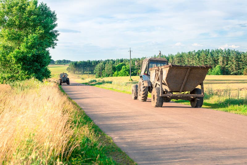 Two Tractors Moving Towards the Dirt Road during the Harvest in the