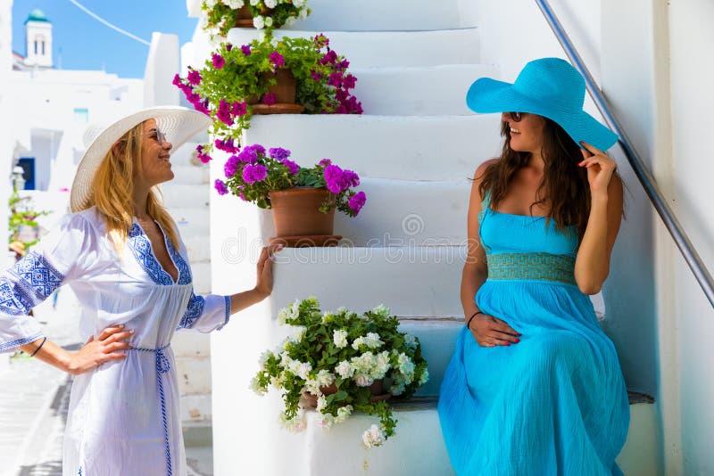 Two traveller woman enjoying the white, picturesque alleys of the Cyclades islands in Greece royalty free stock photography Two traveller woman enjoying the white, picturesque alleys of the Cyclades islands in Greece royalty free stock photography