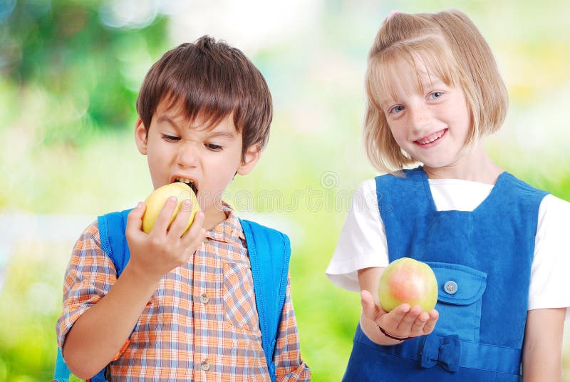 Two very cute children eating fruits outdoor