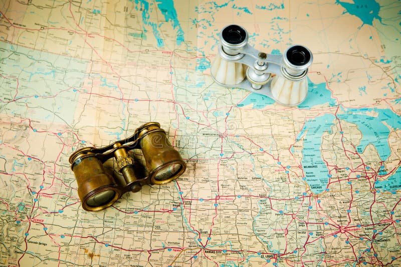 Two vintage binoculars on old map - brass metal body and silver stock image Two vintage binoculars on old map - brass metal body and silver stock image