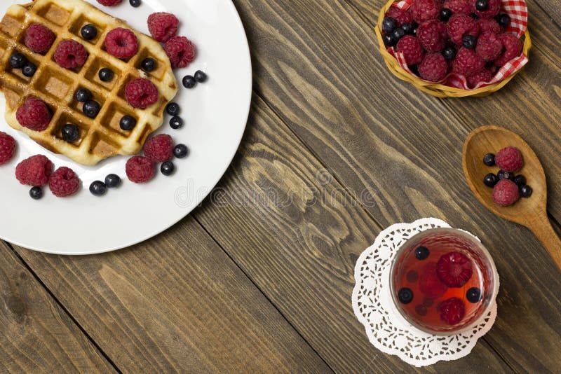 Two waffles on a white plated and glass of juice stock image