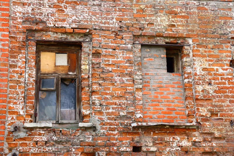 Two windows in an old brick wall, broken red bricks, red brick background stock photography