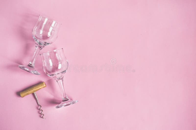 Two wine glasses and a corkscrew on a pink background stock images