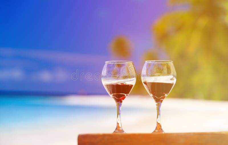 Two wine glasses on sand beach stock photo