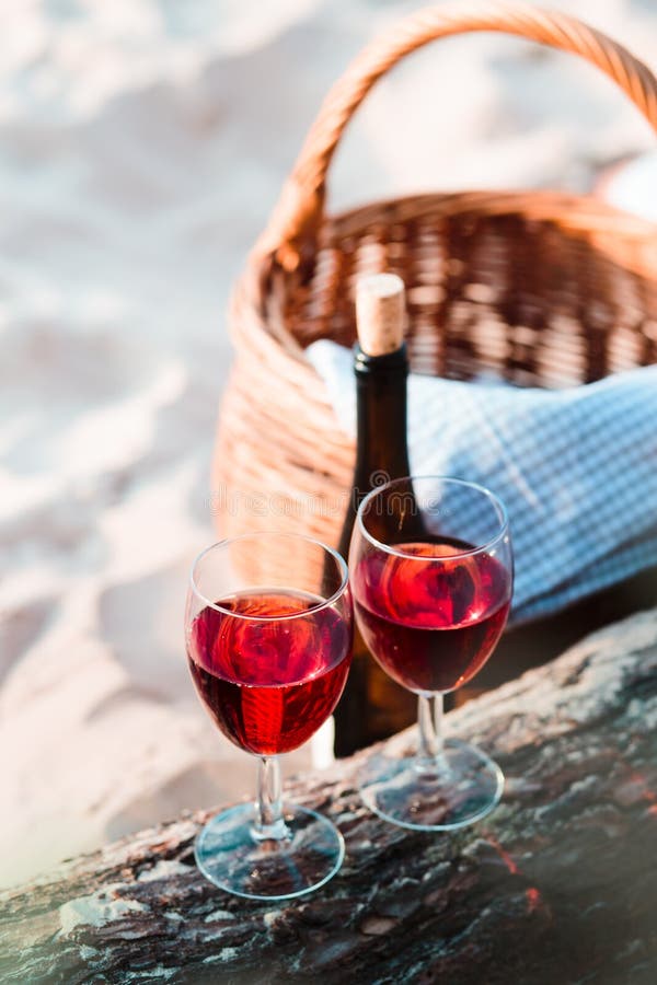 Two wine glasses, wicker basket on beach royalty free stock photos