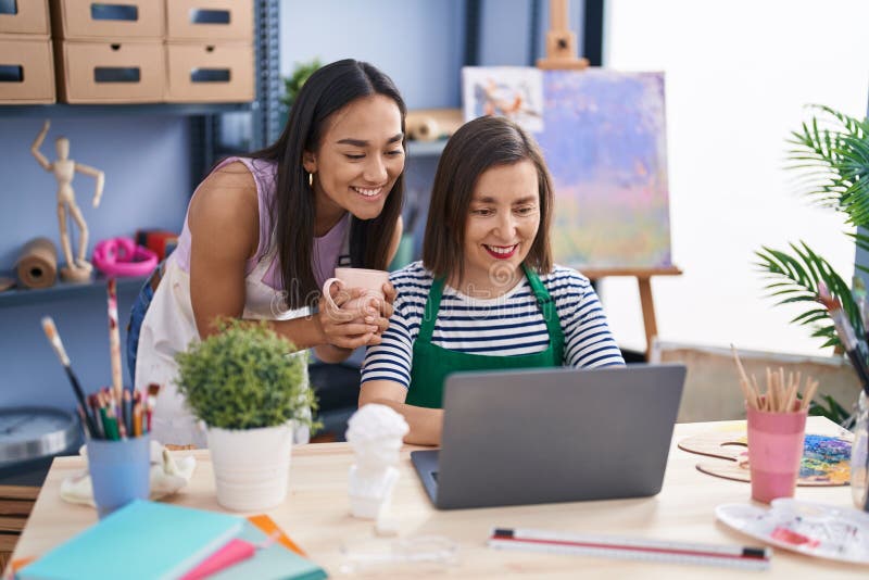 Two Women Artists Using Laptop Drinking Coffee at Art Studio Stock