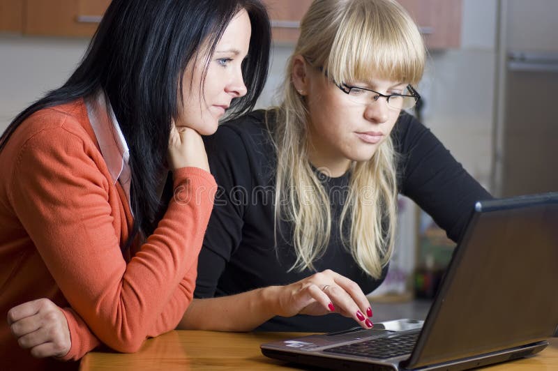 Due giovani donne a guardare lo schermo di un computer portatile.