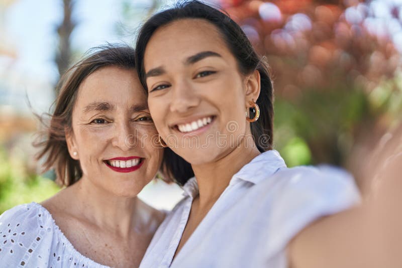 Two women mother and daughter make selfie by camera at park royalty free stock photo