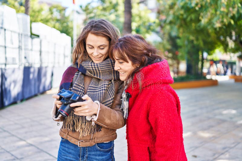 Two women mother and daughter using professional camera at park royalty free stock photo