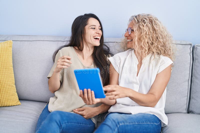 Two women mother and daughter using touchpad at home stock images