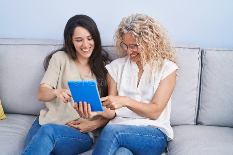 Two women mother and daughter using touchpad at home royalty free stock photo