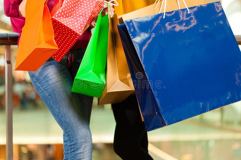 Two women shopping with bags in mall stock photo Two women shopping with bags in mall stock photo