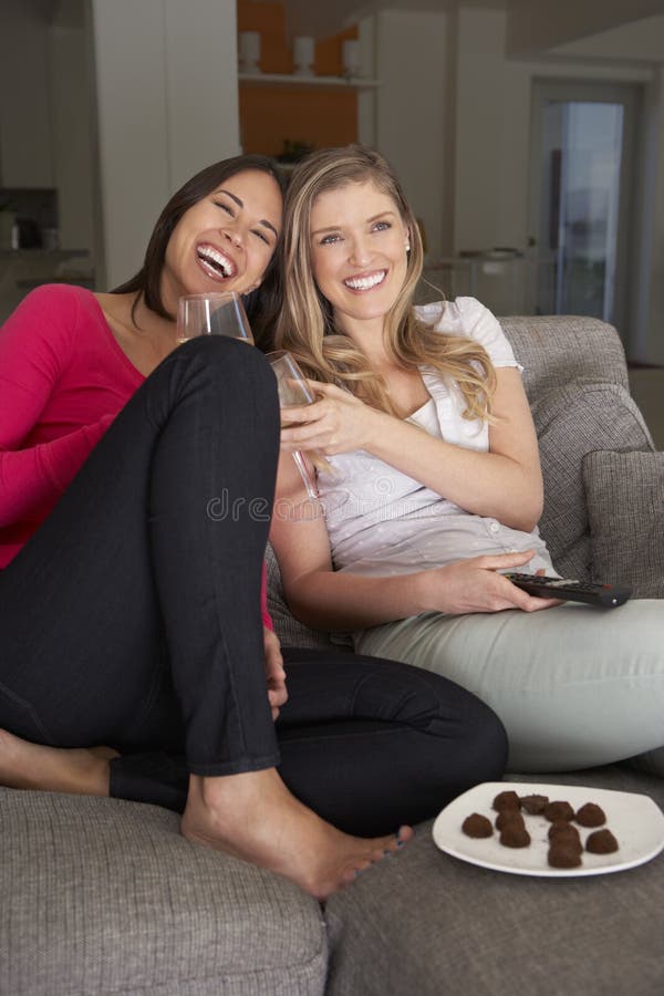 Two Women Sitting On Sofa Watching Tv Drinking Wine Stock Image Image