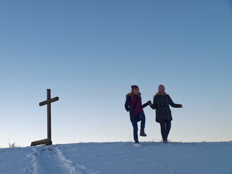 Amoreggiare madre e figlia saltando giù da un pendio innevato nella campagna tedesca in un freddo winterx27s giorno.