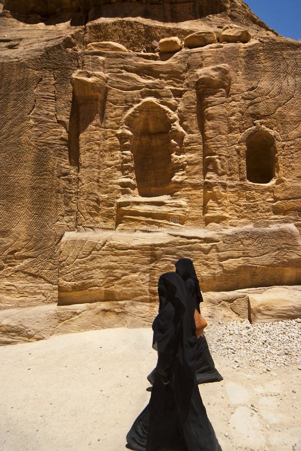 Two women with the veil niqab walking in Petra