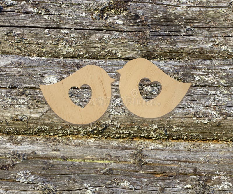 Two wooden birds with hearts on a wooden background. Top view. Valentines days. Love symbol. Greeting card. Greeting card.