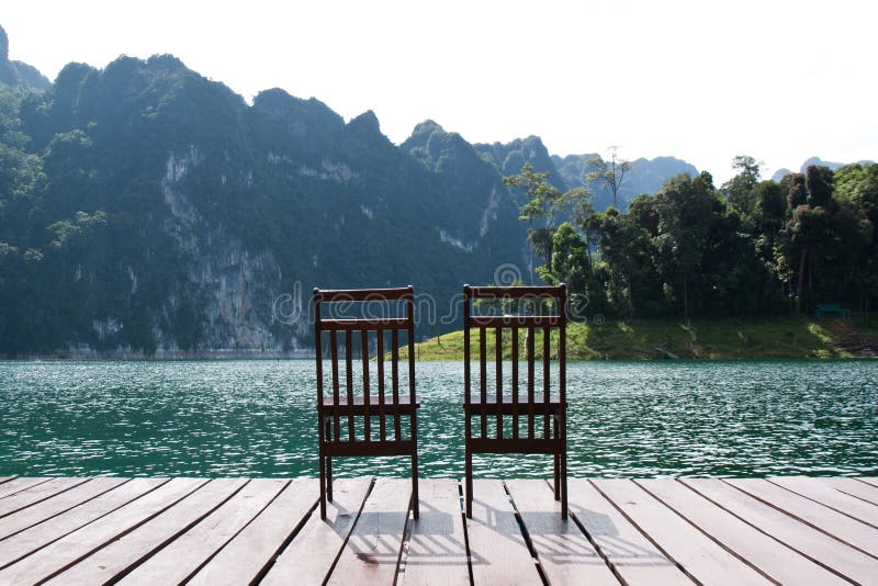 Two wooden chairs on the lake
