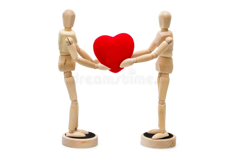 Two wooden dolls, mannequins holding red heart over a white back