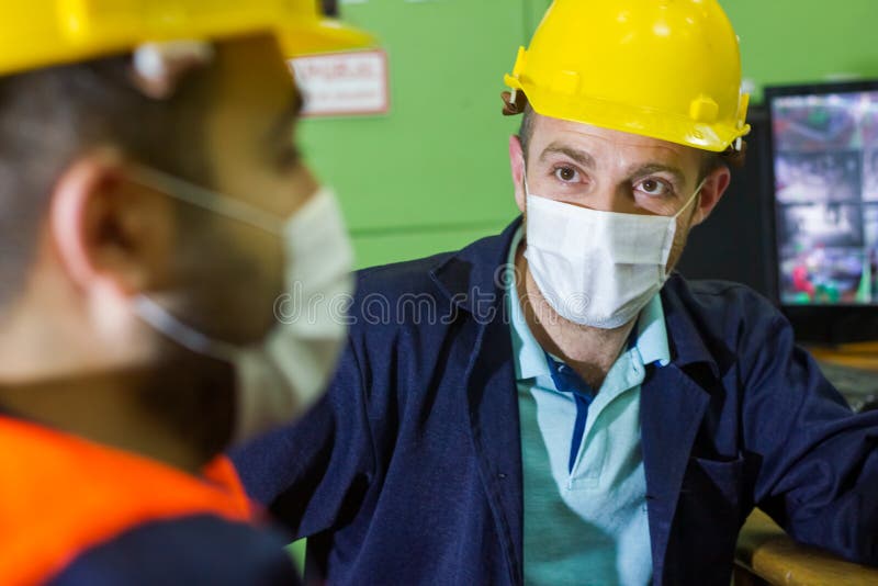 The Two Workers in Protective Masks and Yellow Helmets in Control Panel