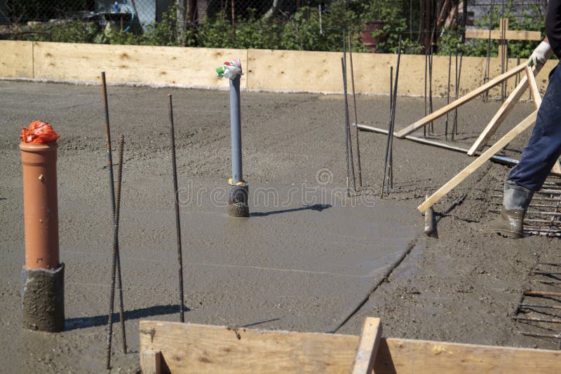 Two Workers in Rubber Boots Stands in Uncluttered Cement and Lev Stock
