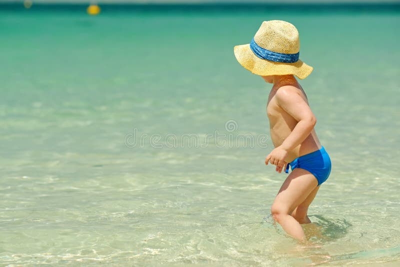 Two year old toddler playing on beach stock photo