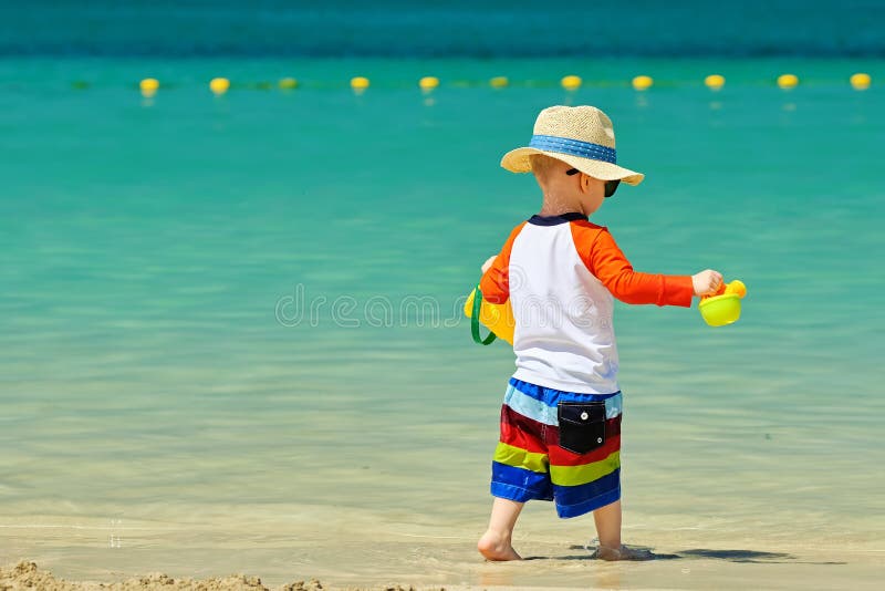Two year old toddler playing on beach stock photos