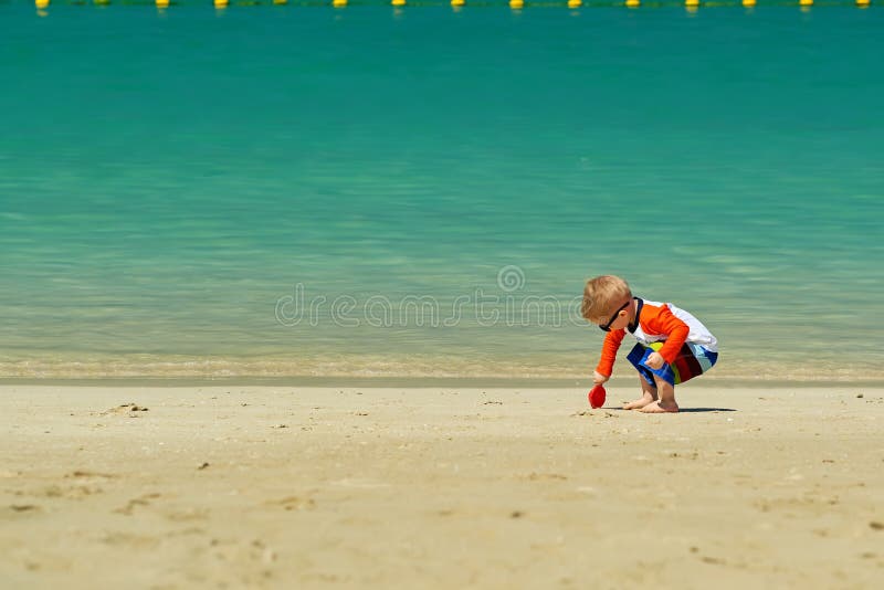 Two year old toddler playing on beach stock images