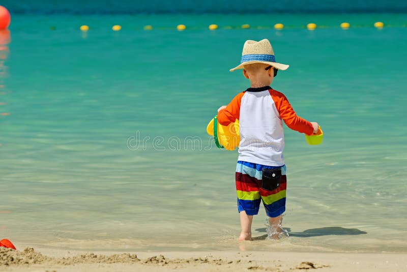 Two year old toddler playing on beach royalty free stock photo