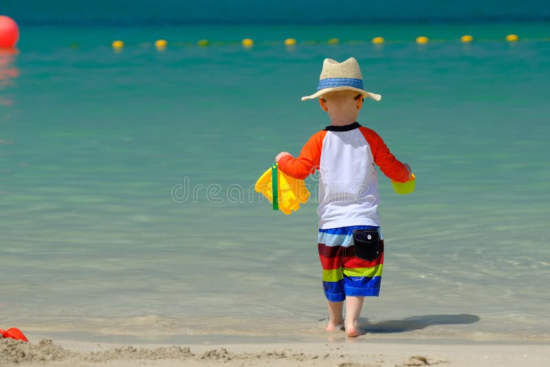 Two year old toddler playing on beach stock photography