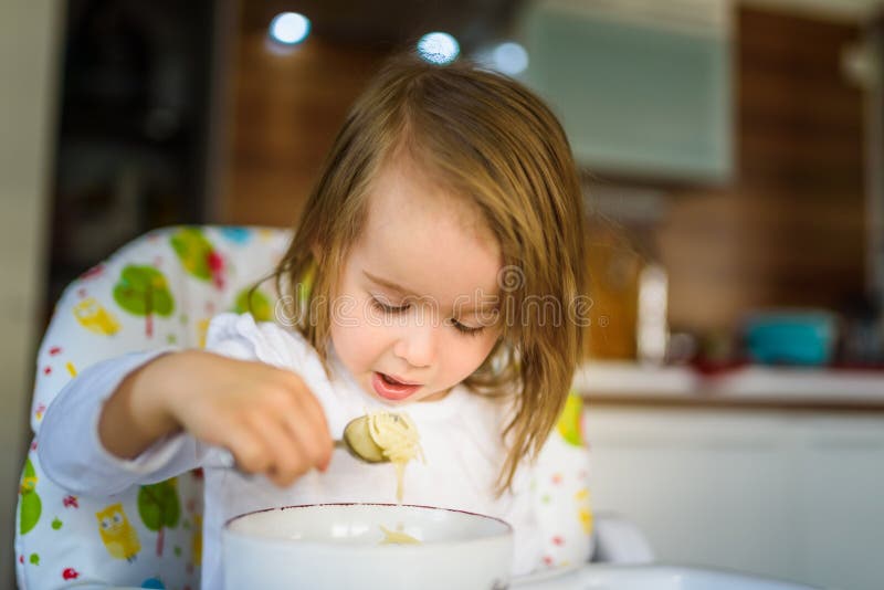 Two Years Old Eats Chicken Soup by Herself with a Spoon Stock Image