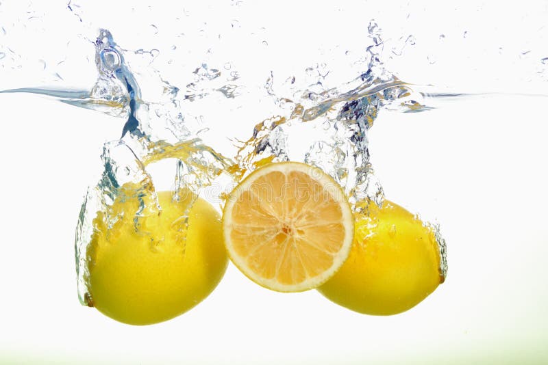 Two yellow lemons and lemon slice spash in water on white background