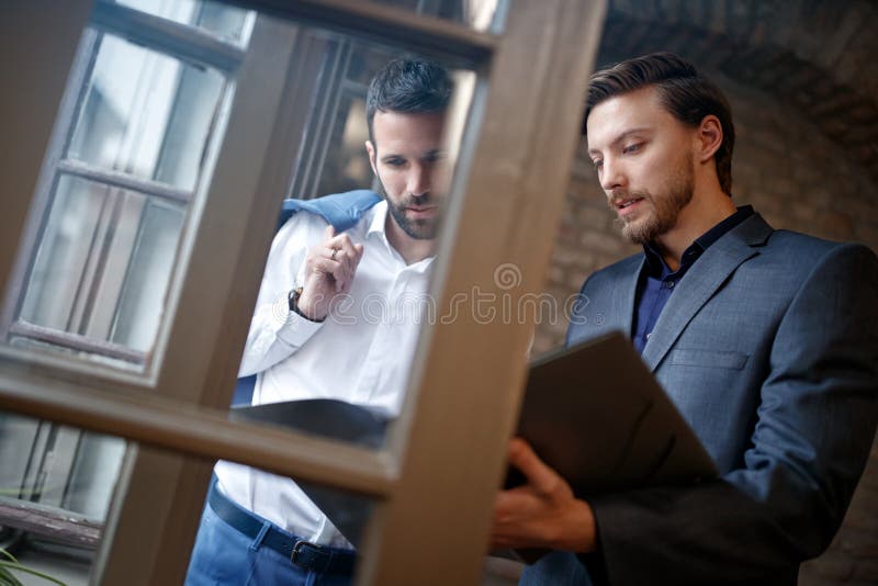 Two young businessmen in office reading business plan royalty free stock images Two young businessmen in office reading business plan royalty free stock images