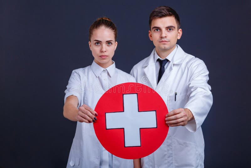 Two Doctors in Uniform, Hold One Medical Sign, a White Cross in a ...