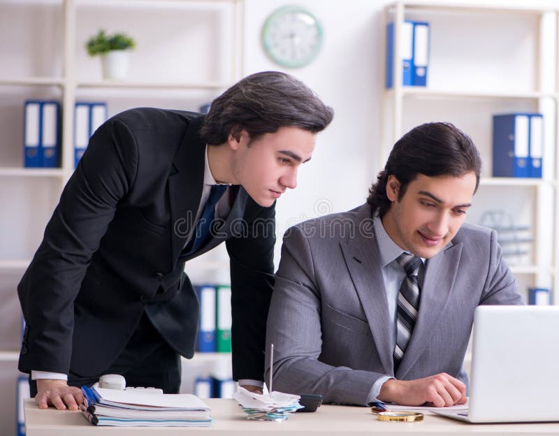 Two young employees working in the office