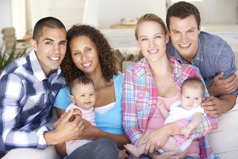 Two Young Family With Babies On Sofa At Home stock photo Two Young Family With Babies On Sofa At Home stock photo