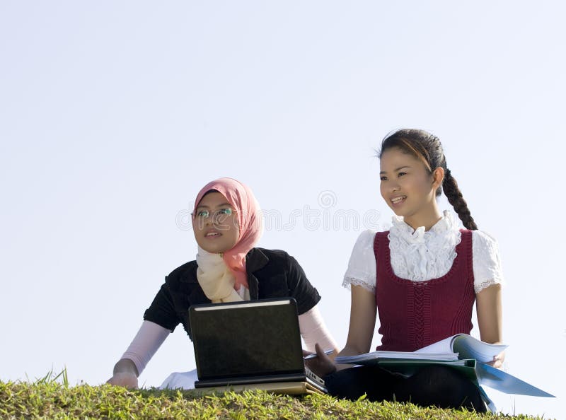 Two young girl studying together