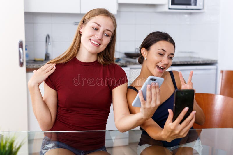 Two Young Girlfriends Making Selfie by Phone and Smiling at Table Stock ...
