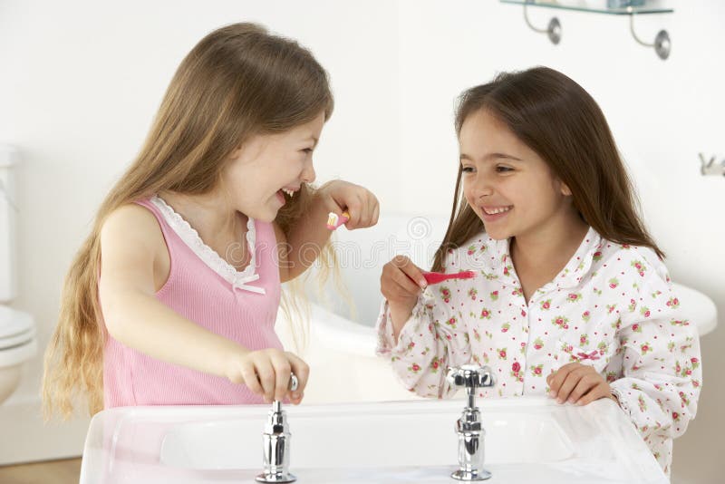 Two Young Girls Brushing Teeth at Sink Stock Photo Image of home