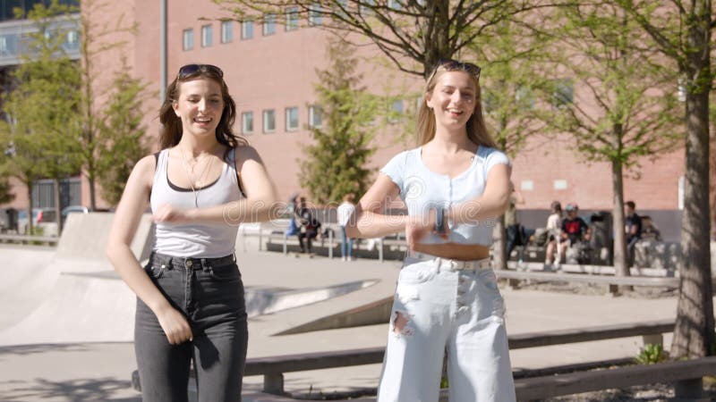 Two young girls doing a synchronized TikTok dance.