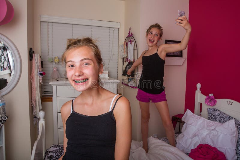 Two young girls playing and taking selfies in their room. Two young girls playing and taking selfies in their room