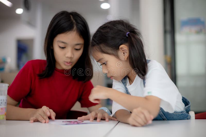 Two young girls are sitting at a table royalty free stock images
