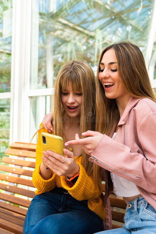 Two Girls Smile While A Musician Plays Guitar And Sings Stock Image