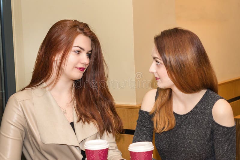 Two young girls talking in a cafeteria stock photo Two young girls talking in a cafeteria stock photo