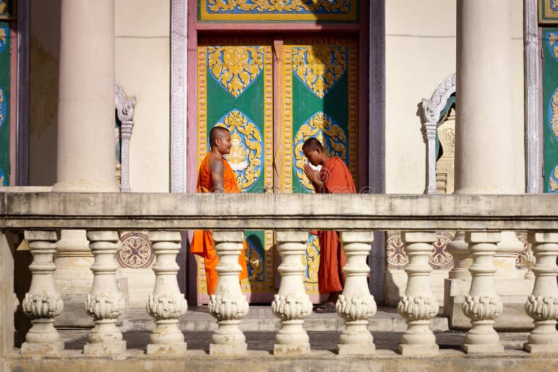 Two young monks meet and salute in buddhist pagoda