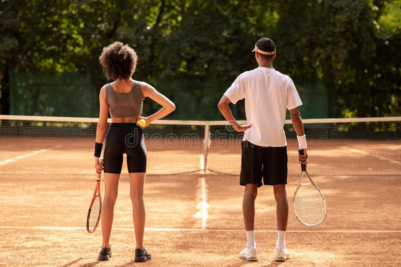 Two young people having a workout at tennis court royalty free stock photos