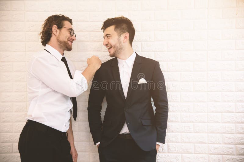 Two young smart businessmen talking together during leisure time at indoor. Business teamwork and coworker concept, Relax concept stock photos Two young smart businessmen talking together during leisure time at indoor. Business teamwork and coworker concept, Relax concept stock photos