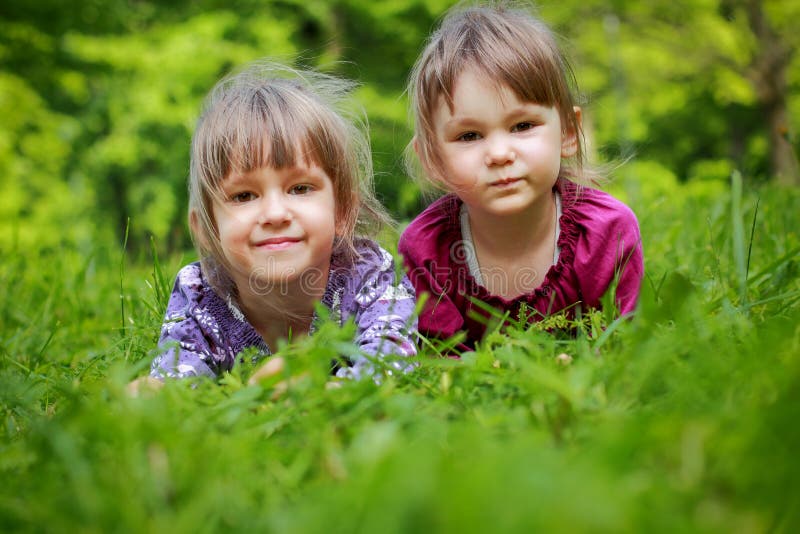 Two Young Smiling Girls in the Grass Stock Photo - Image of girls ...