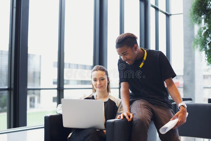 Two young students using laptop in campus stock photos Two young students using laptop in campus stock photos